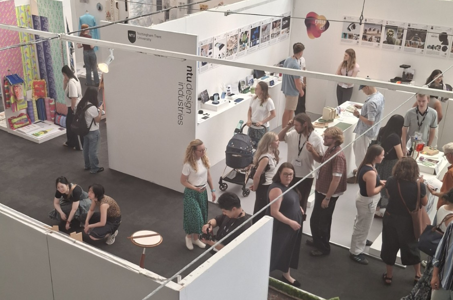 People at an exhibition of graduate design work.