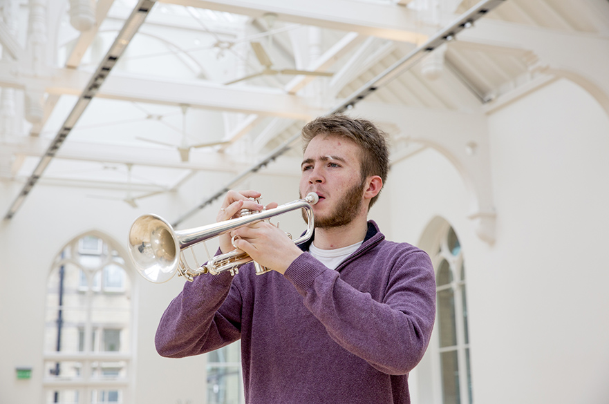 Male student playing a trumpet.