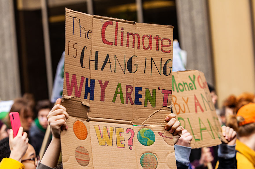 People at an environment rally holding up signs