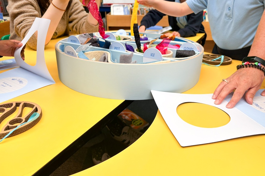 People using craft materials on a table.