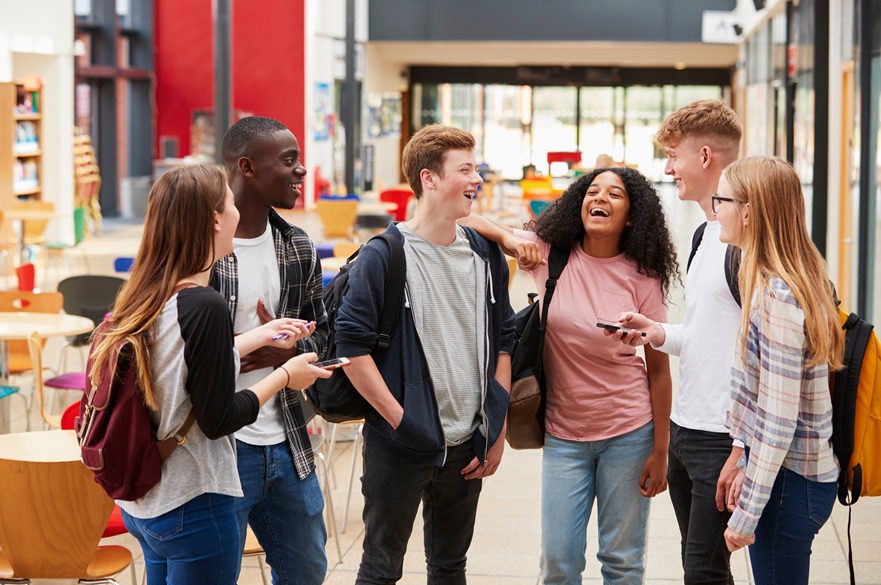 Group of young people laughing in a college common room