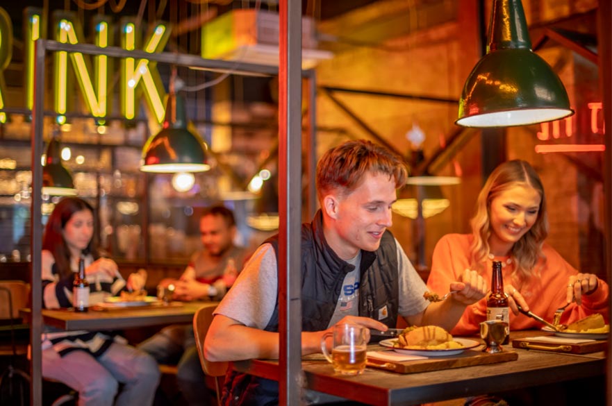 A male and female student eating in a brightly lit Nottingham restaurant