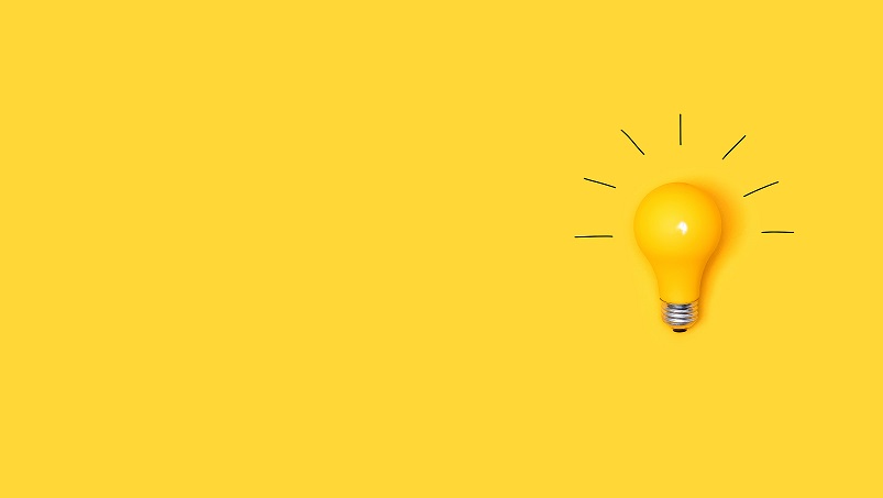 An image of a lit up light bulb on a yello background