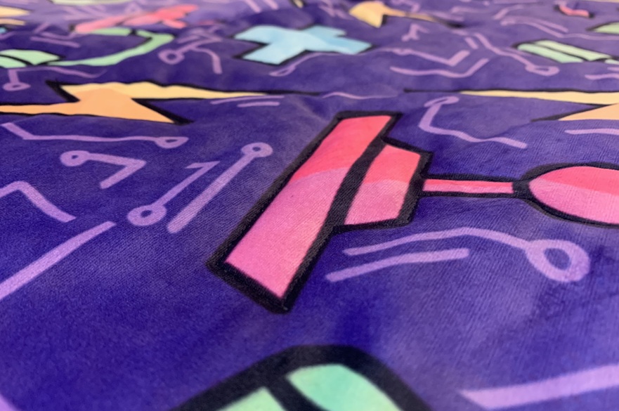 The brightly coloured pattern on the fabric covering for a gaming chair seat.