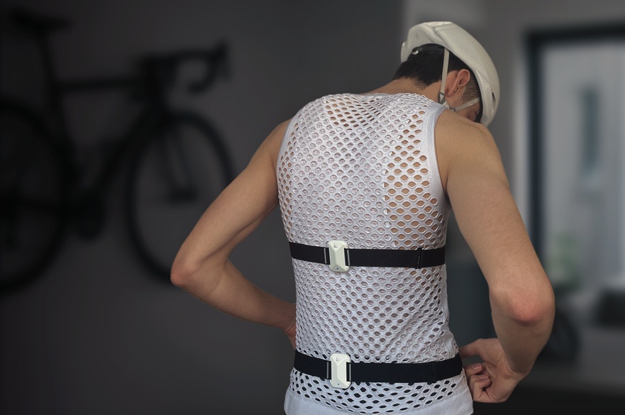A person wearing a 'wearable' that monitors back posture for cyclists.