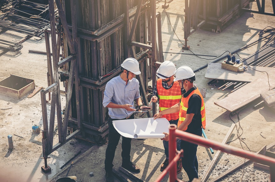 Workers at a construction site looking at blueprints