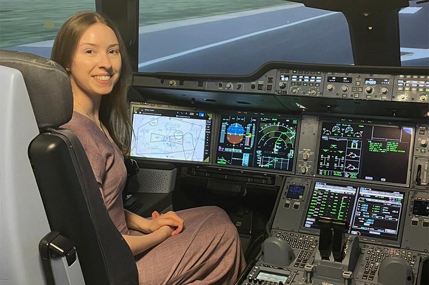 Sophie posing for a picture inside of an aeroplane cabin