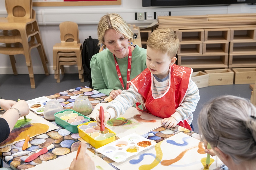 Early years practitioner and child are playing table top activities