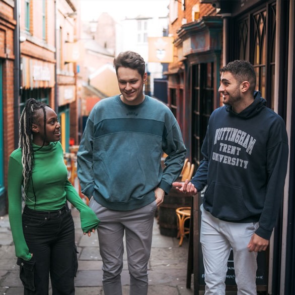 Three students chatting and walking through Nottingham city centre