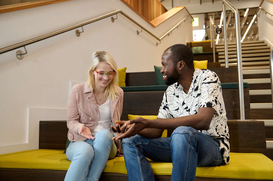 Two students sitting on the stairs in the DaDA building