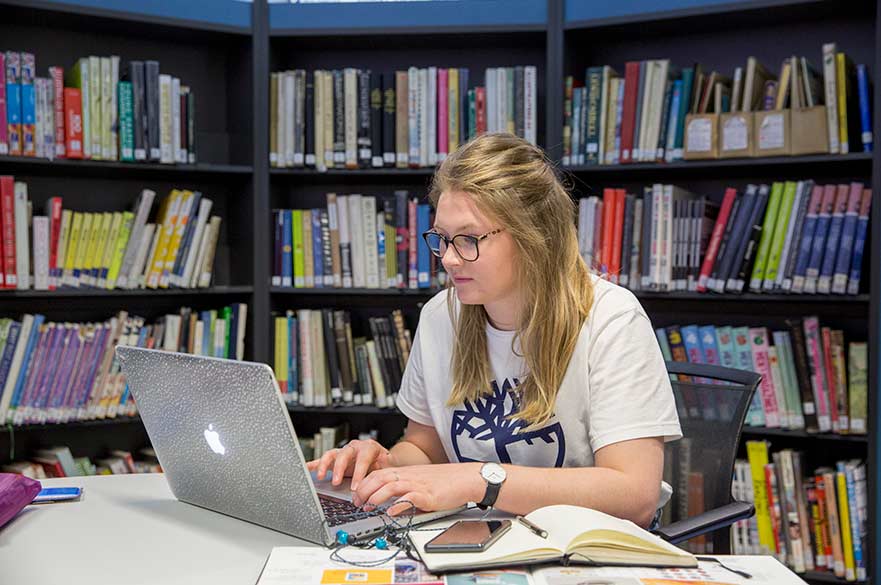 Student using laptop in library