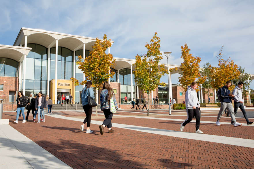Students walking in front of the Pavilion building, Clifton Campus