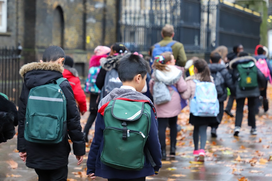 Group of children in backpacks on the way to school