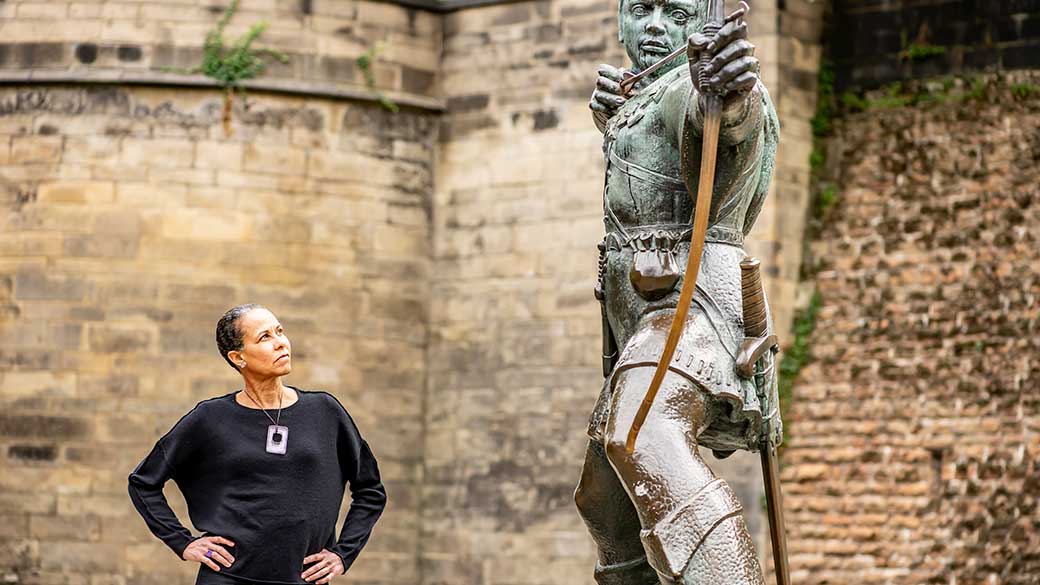 Senior Lecturer Deanne Bell standing next to Robin Hood statue in Nottingham