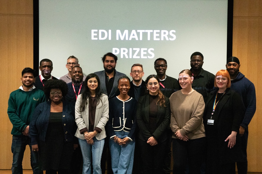 Group of students and staff in front of EDI Prize Winners screen