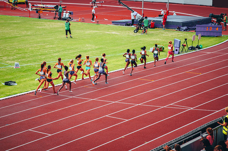 Female track and field race at athletics stadium. Professional female runners. Photo for athletics competition at summer Olympic game Tokyo 2020.