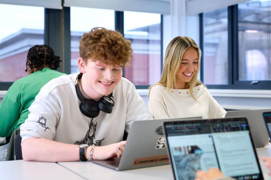 Two students sat at a desk while taking part in a Sociology seminar