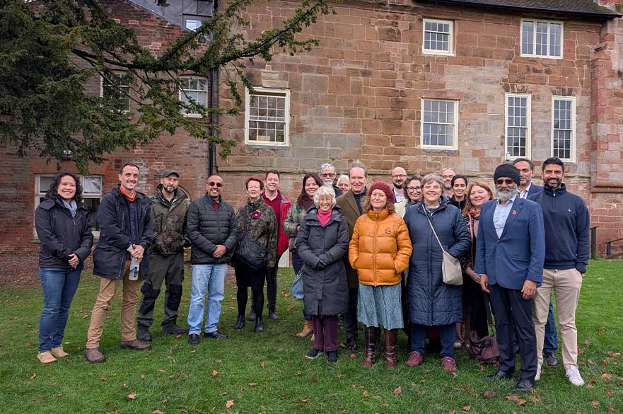 Members of diverse faith communities, National Trust staff and NTU researchers gather outside a historic building as part of the Nature in Faiths project, which explores how faith groups can support nature connection and environmental stewardship.