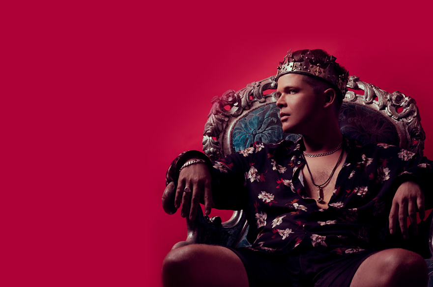 Luke Wright sat on a throne-like chair with a crown on his head.