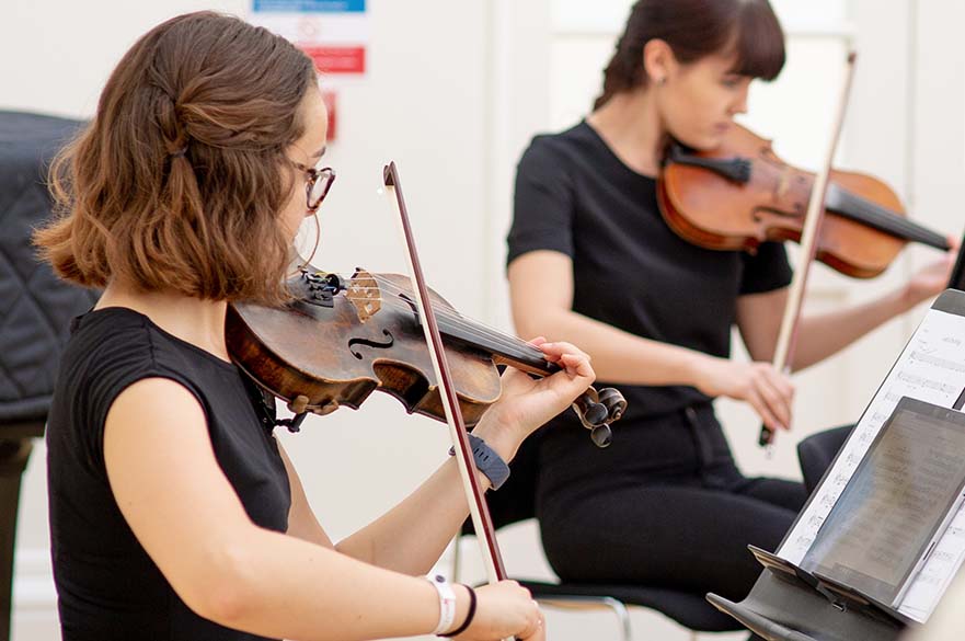 Two female students playing the violin