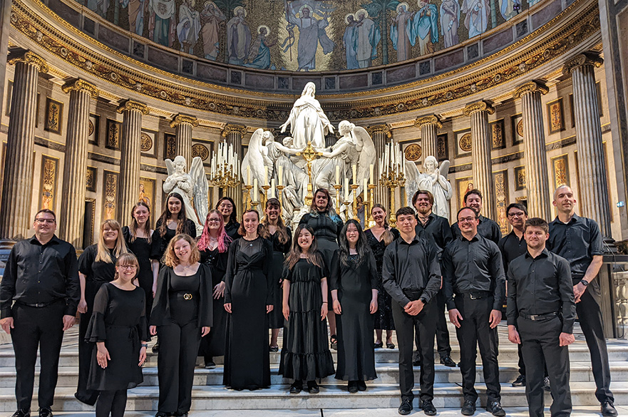 The NTU Chamber Choir wearing black concert dress in a hall.