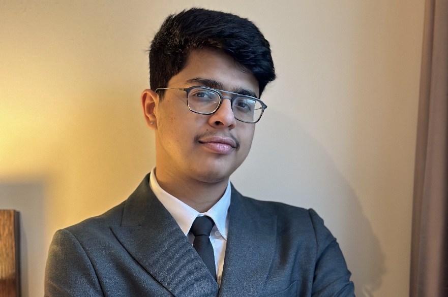 A person wearing a suit, posed for a photograph.