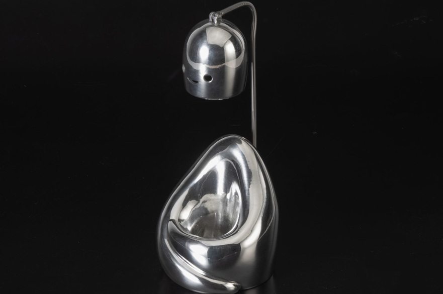 A candle holder and burner made out of pewter