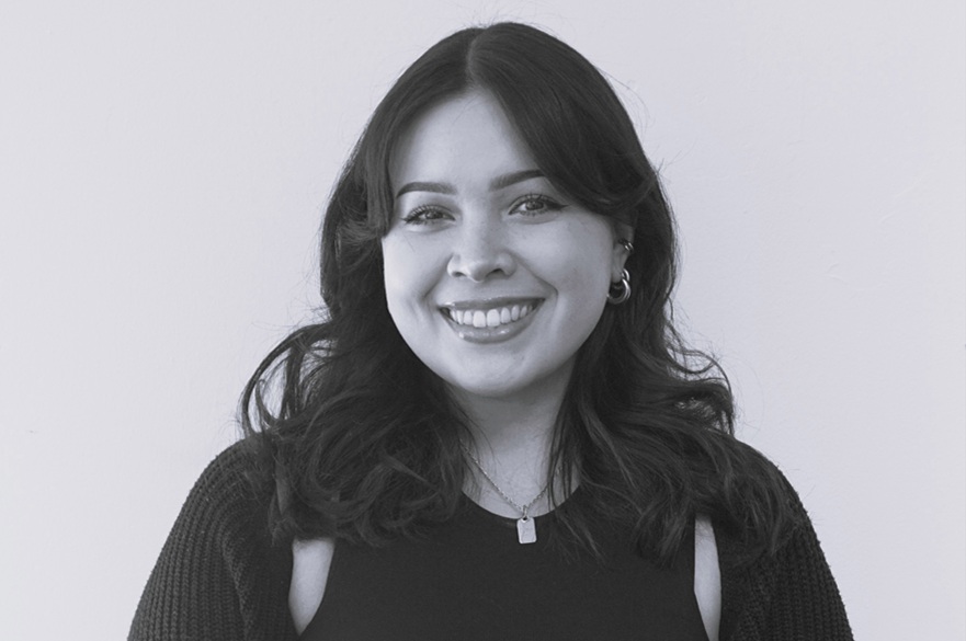 A person facing the camera to have their picture taken. The photo is black-and-white.