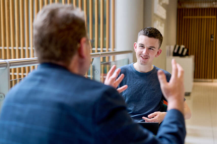 student and staff member in conversation