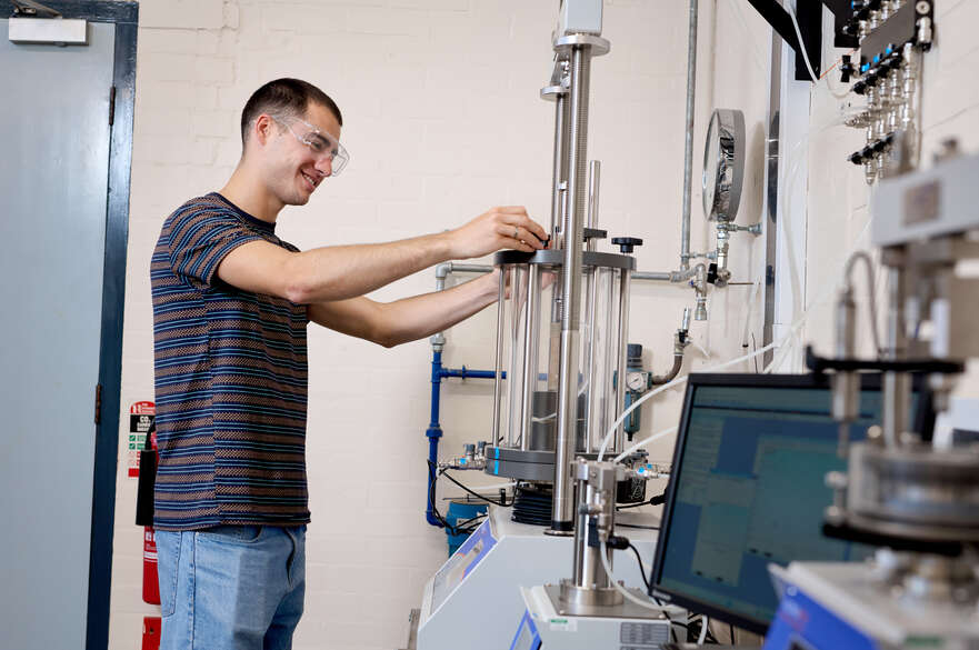 Student testing ground materials on machine
