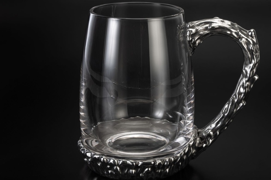 A tankard made out of glass and peweter.