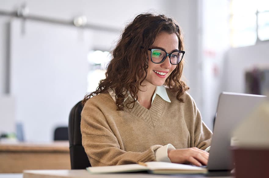 A person sitting at a laptop smiling