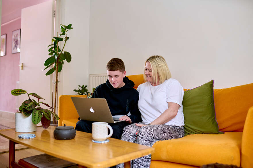 Picture of a student parent with their child and a laptop