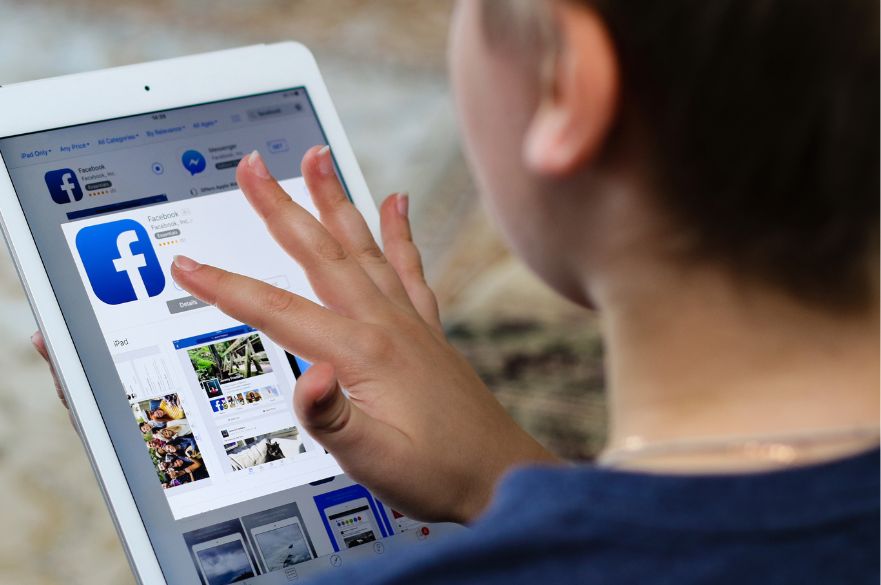 Child on an ipad downloading Facebook UK social ban
