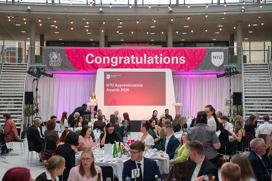 Image of tables in front of a screen which says Apprenticeship Awards ceremony 2026
