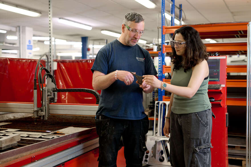 Student and technician looking at metal object