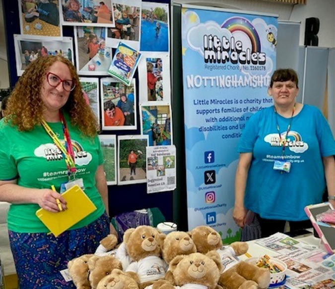 Two students are standing a table promoting the charity Little Miracles 