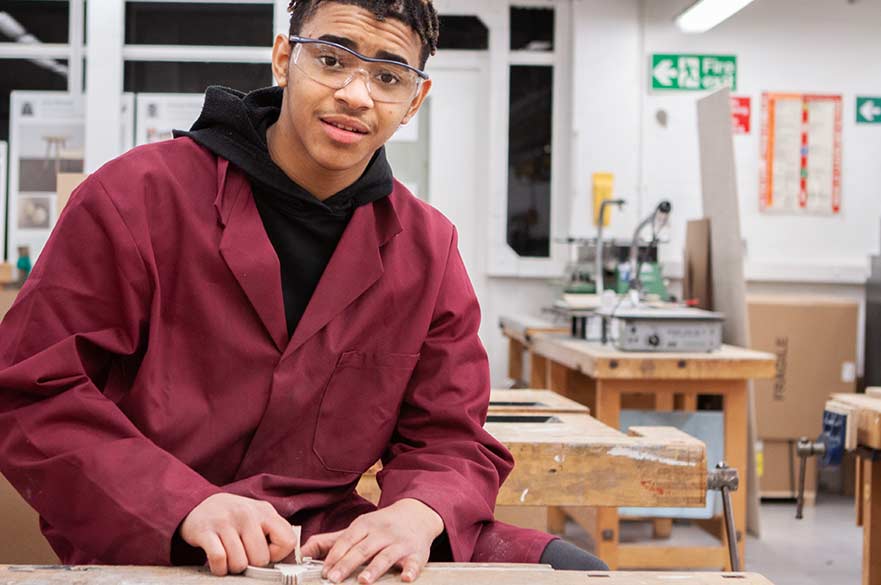 student in workshop working wearing safety goggles