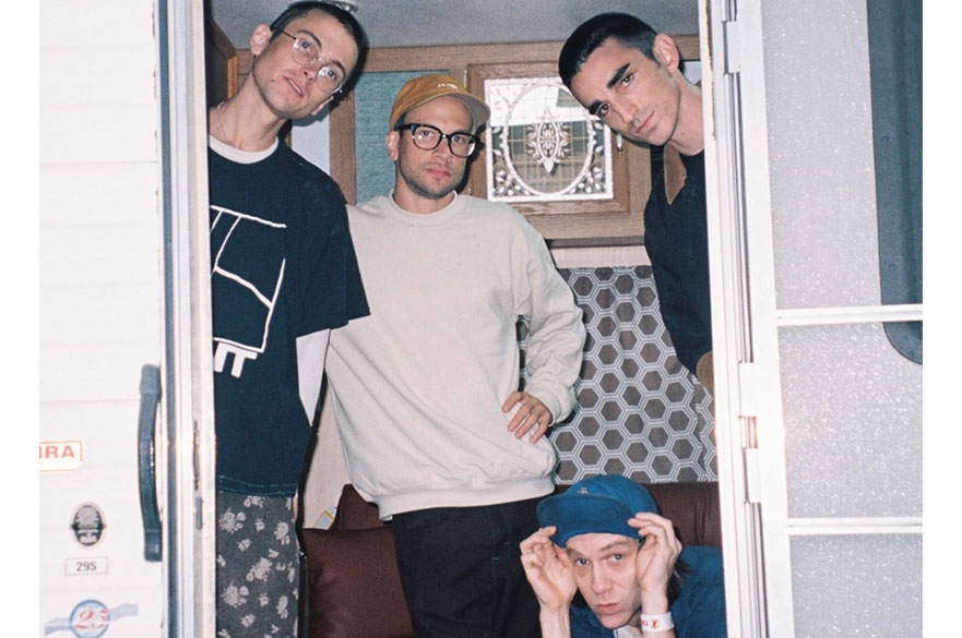 A photo of four men looking out of a doorway