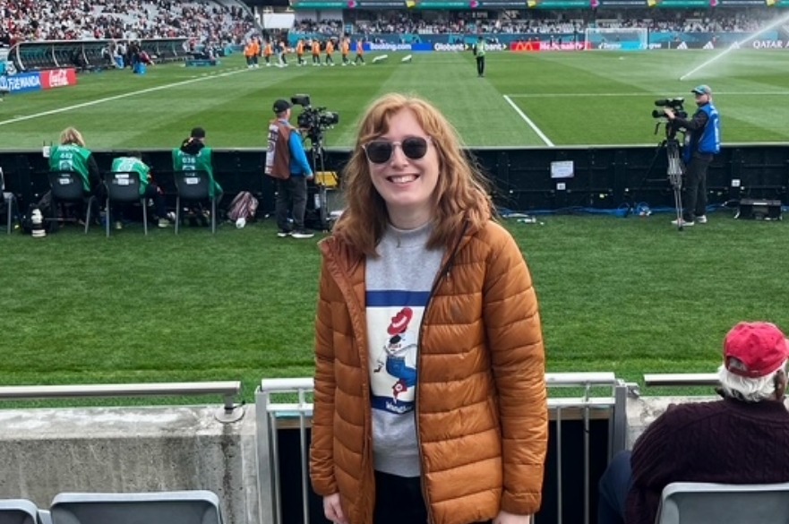 Nancy posing for the camera with a football pitch in the background