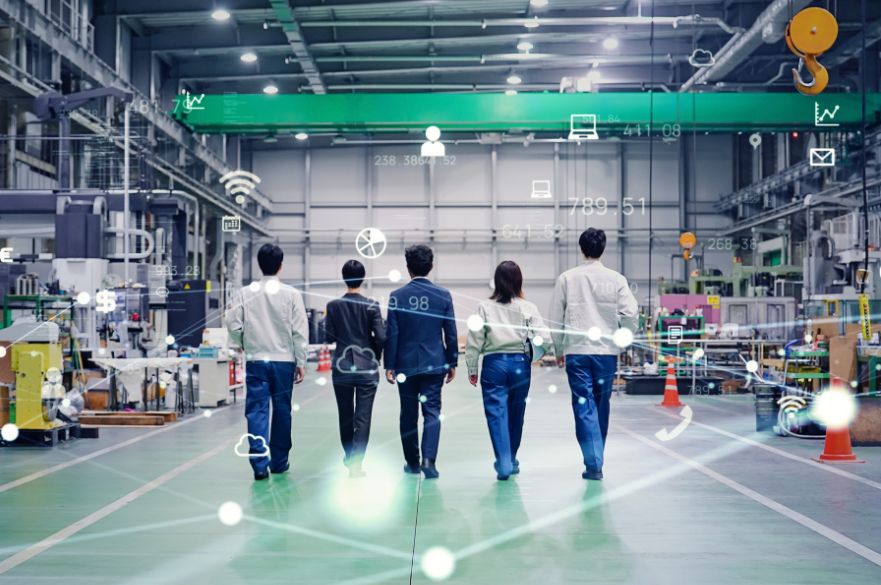 Team walking through a factory with AI and computing icons around them
