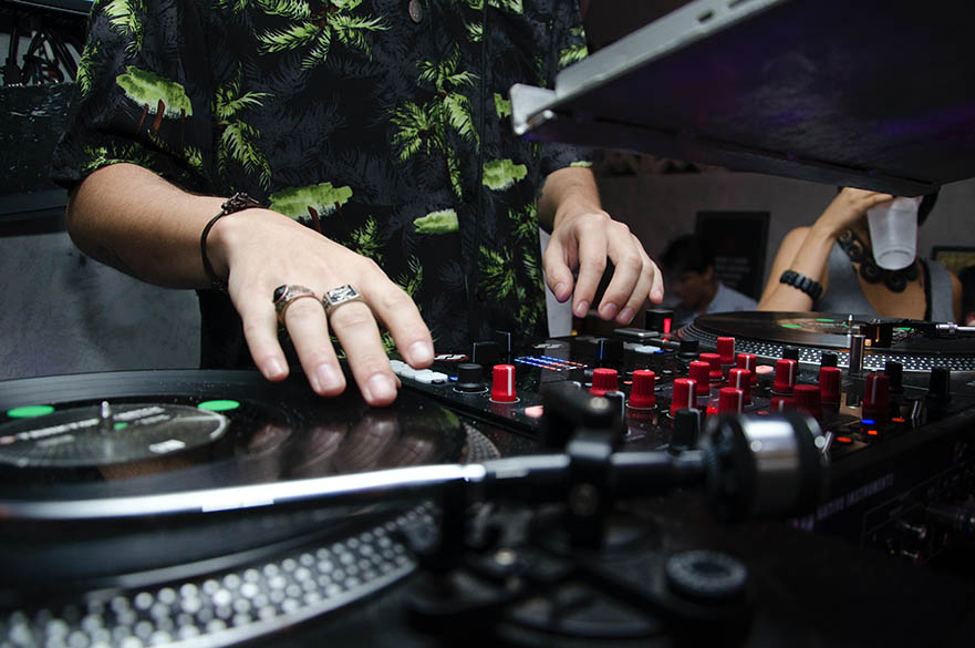 A DJ deck with a mans hands playing them.