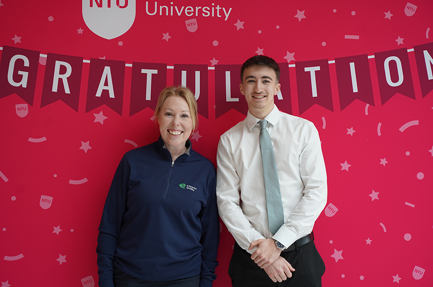 NTU student Daniel Rowe and a colleague from Enterprise Mobility pose in front of an NTU graduation backdrop, celebrating their placement partnership