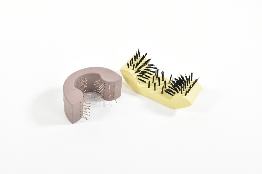 Two hair brushes on a white surface.