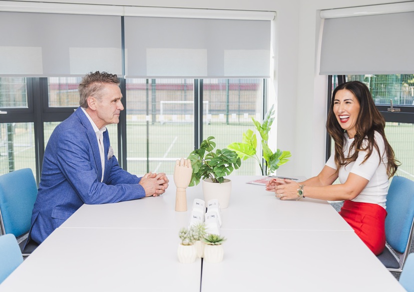 Two people are sitting at a co working desk
