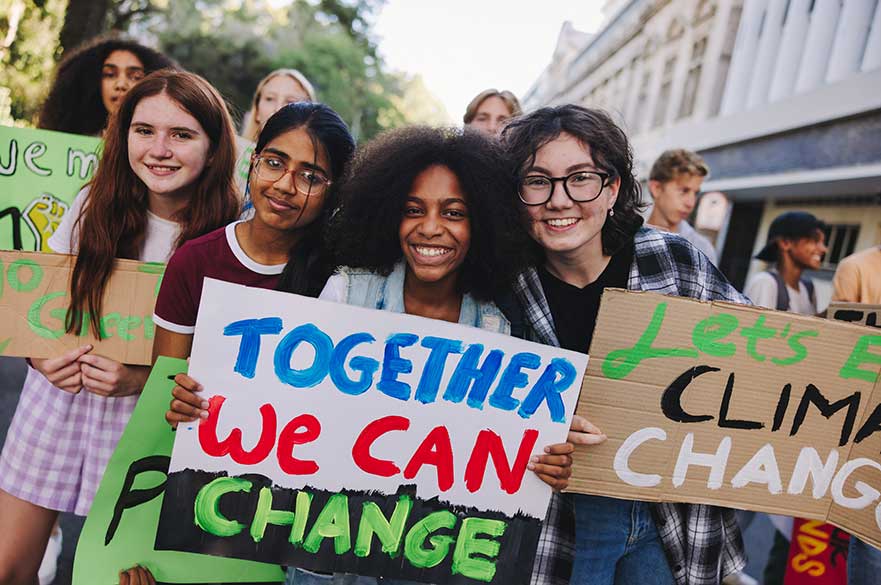 Young people holding up climate protest signs