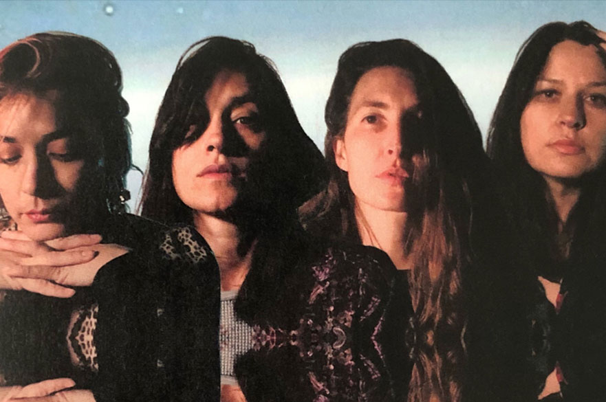The members of Warpaint stood in a line together. 