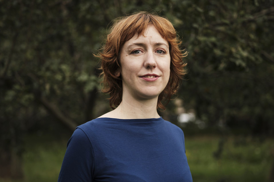 Photograph of Holly Williams wearing a navy top in nature.