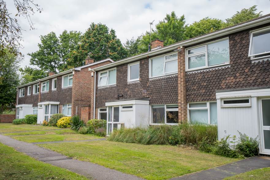 Four semi-detached houses on College Drive, each with paths, lawns and greenery leading up to their porches.