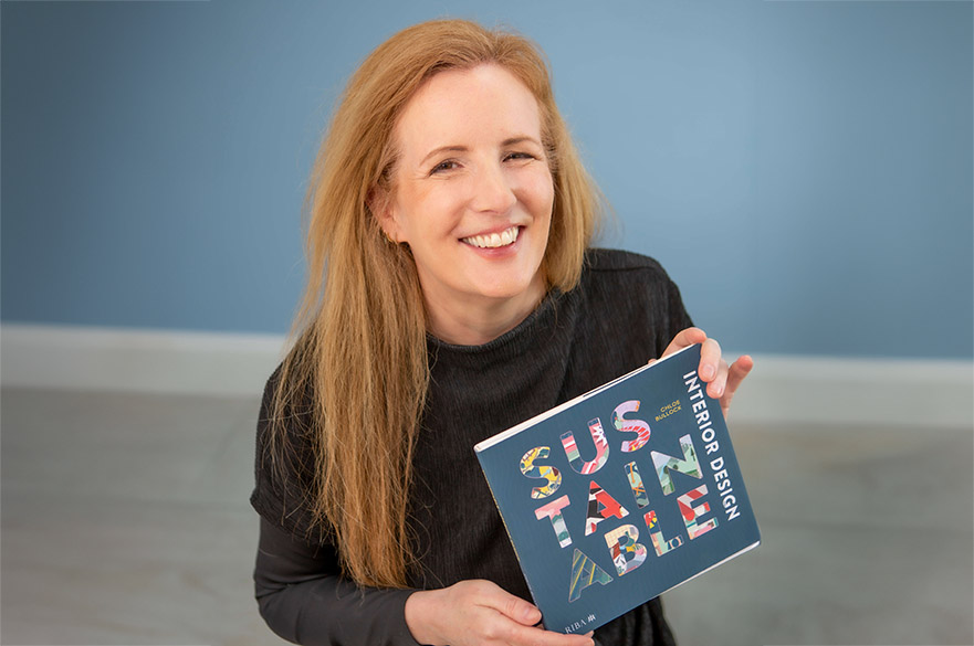 Chloe Bullock holding her recently published book about design techniques